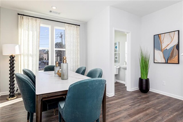 dining space with visible vents, baseboards, and dark wood finished floors