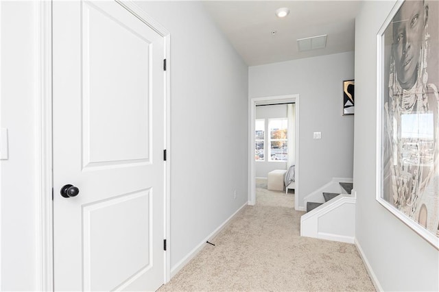 hallway with visible vents, stairway, baseboards, and carpet floors