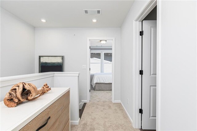 hall with recessed lighting, visible vents, baseboards, and light colored carpet