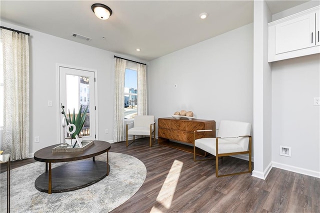 living area with dark wood finished floors, visible vents, recessed lighting, and baseboards