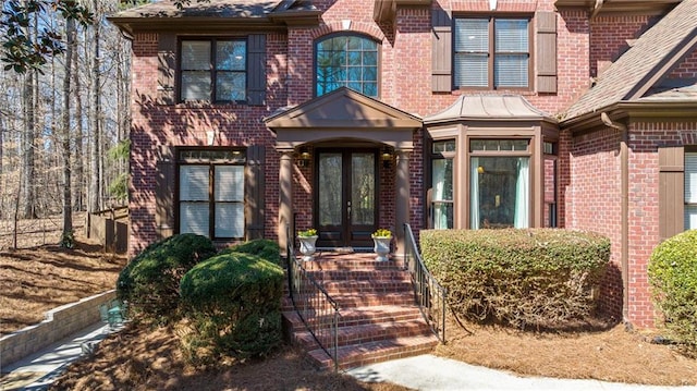 doorway to property featuring french doors and brick siding