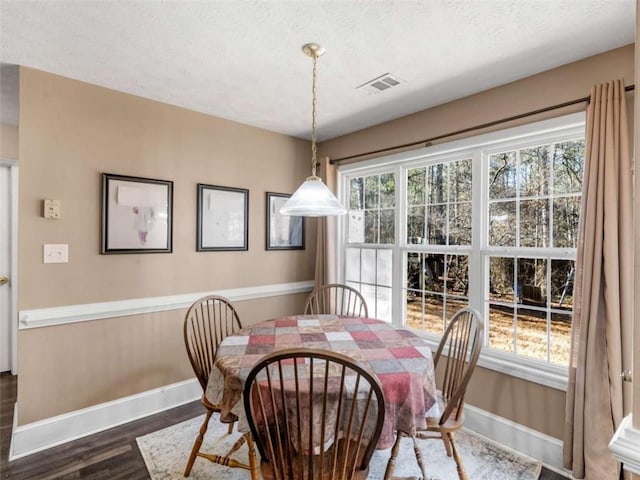 dining space featuring dark hardwood / wood-style floors and a textured ceiling