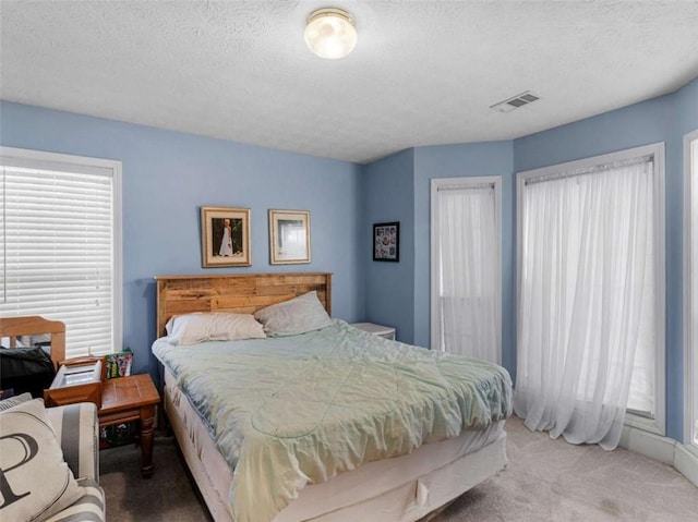 carpeted bedroom with a textured ceiling