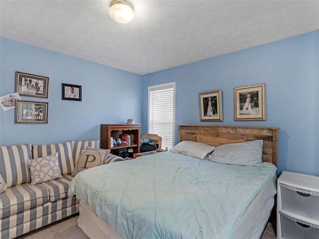 bedroom featuring light colored carpet and a textured ceiling