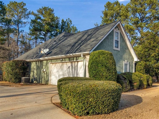 view of side of property featuring a garage and central AC unit