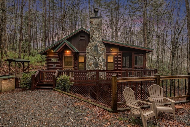 back house at dusk with a wooden deck