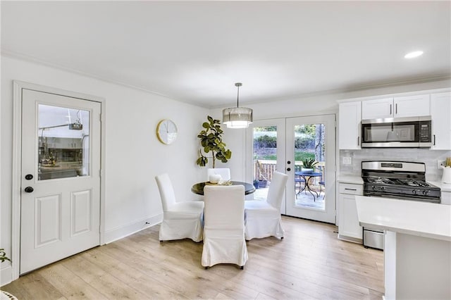 dining area featuring french doors, light hardwood / wood-style floors, and crown molding