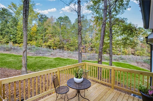 wooden terrace featuring a lawn