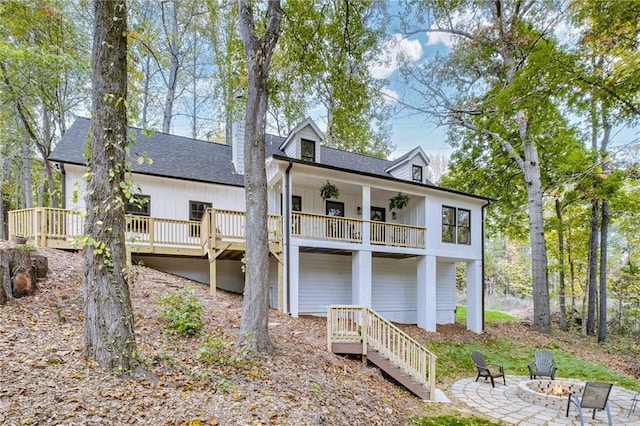 rear view of property featuring a fire pit and a deck