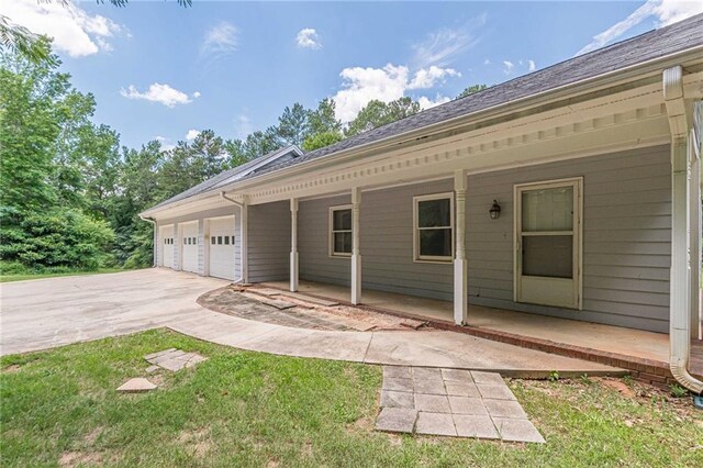 exterior space with covered porch, a yard, and a garage