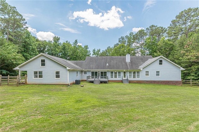 back of property featuring central AC and a lawn