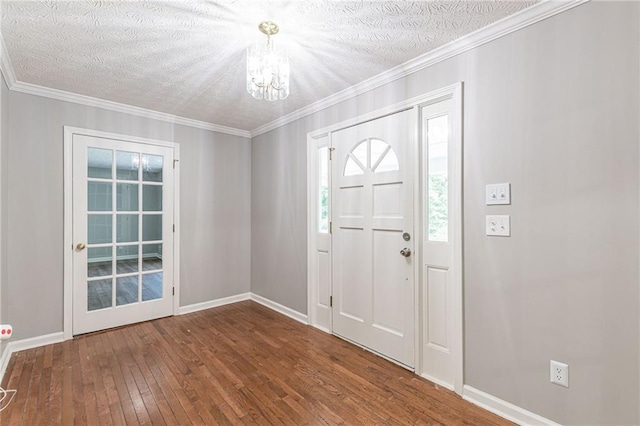 entrance foyer featuring hardwood / wood-style flooring, a textured ceiling, and ornamental molding