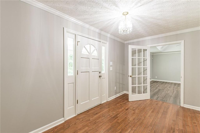 entryway with french doors, ornamental molding, a textured ceiling, and hardwood / wood-style floors