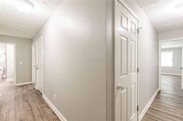 hallway featuring a textured ceiling and light wood-type flooring