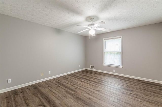 empty room with dark hardwood / wood-style floors, a textured ceiling, and ceiling fan