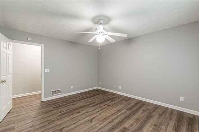 spare room with ceiling fan, a textured ceiling, and dark hardwood / wood-style floors