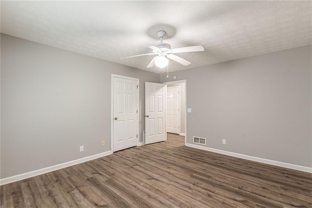 spare room featuring ceiling fan, a textured ceiling, and dark hardwood / wood-style flooring