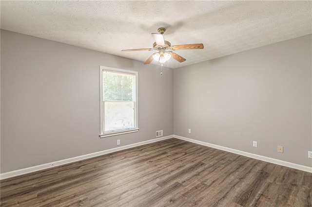 empty room featuring a textured ceiling, dark hardwood / wood-style floors, and ceiling fan