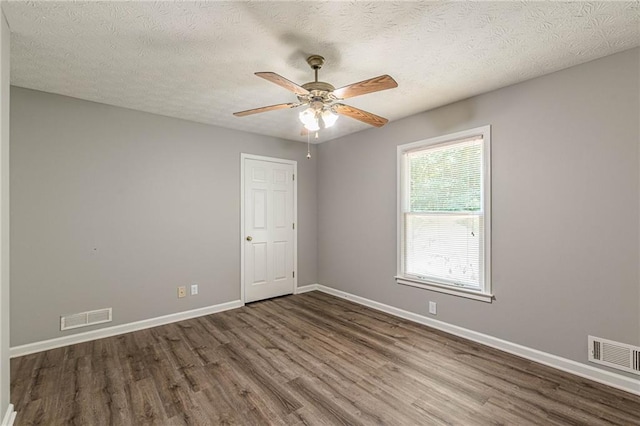 unfurnished room featuring dark hardwood / wood-style floors, a textured ceiling, and ceiling fan