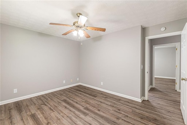 unfurnished room featuring a textured ceiling, dark wood-type flooring, and ceiling fan