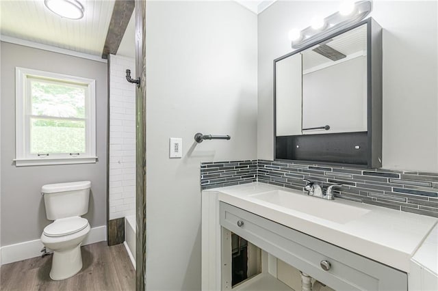 bathroom featuring hardwood / wood-style floors, tasteful backsplash, toilet, a shower with shower door, and vanity