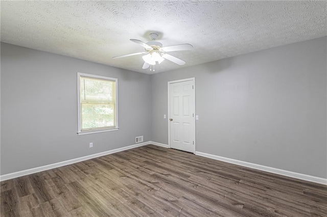 unfurnished room with ceiling fan, a textured ceiling, and dark hardwood / wood-style flooring