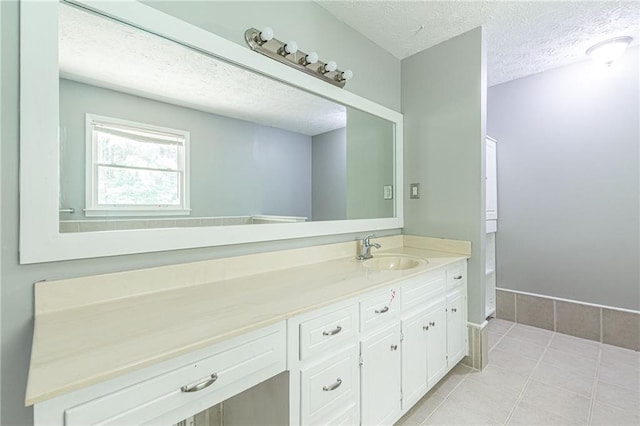 bathroom with vanity, a textured ceiling, and tile patterned flooring