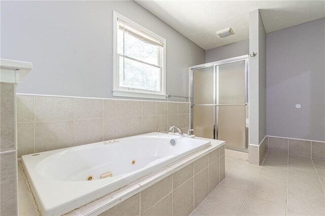 bathroom featuring plus walk in shower and tile patterned flooring