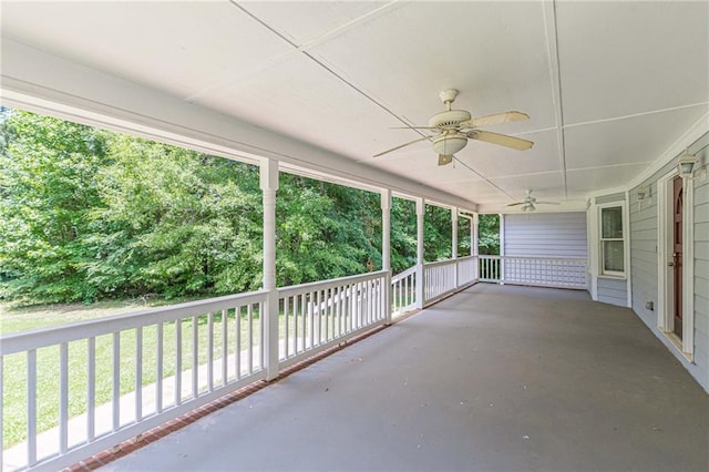 unfurnished sunroom with ceiling fan