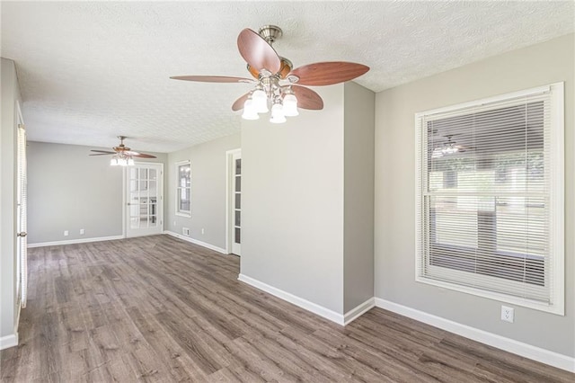 spare room with a wealth of natural light, a textured ceiling, wood-type flooring, and ceiling fan