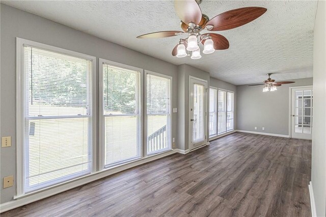 interior space featuring ceiling fan, a healthy amount of sunlight, and dark hardwood / wood-style flooring