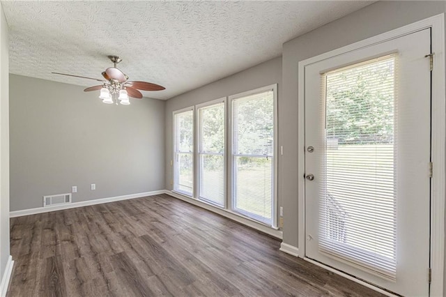 interior space with a wealth of natural light, hardwood / wood-style floors, a textured ceiling, and ceiling fan