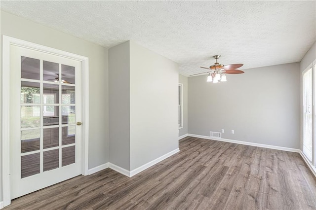 empty room with hardwood / wood-style floors, a textured ceiling, and ceiling fan