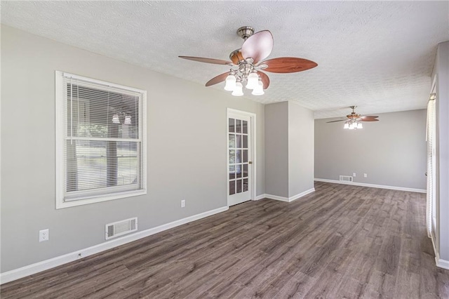 spare room with dark wood-type flooring, ceiling fan, and a textured ceiling