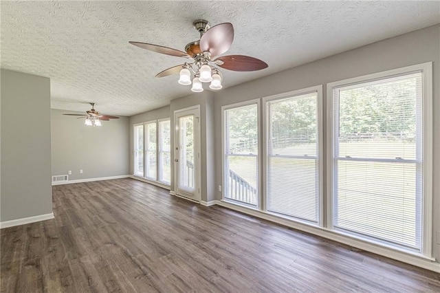 empty room featuring a textured ceiling, ceiling fan, and dark hardwood / wood-style flooring