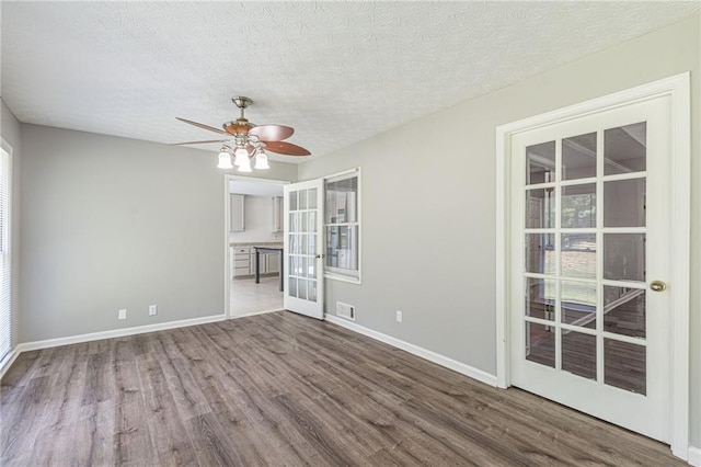 spare room with french doors, a textured ceiling, hardwood / wood-style flooring, and ceiling fan