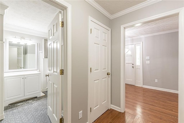 corridor with crown molding, a textured ceiling, and wood-type flooring