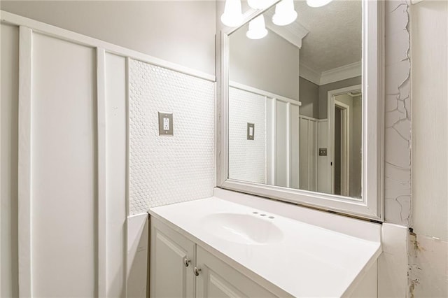 bathroom featuring vanity, ornamental molding, and a textured ceiling