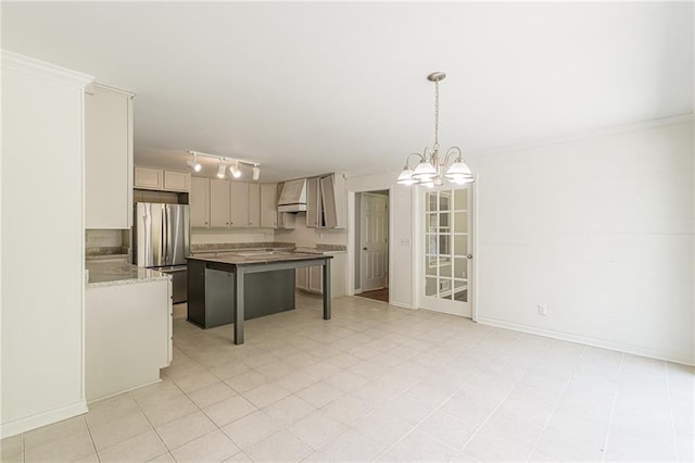 kitchen with a breakfast bar, a chandelier, stainless steel refrigerator, a center island, and decorative light fixtures