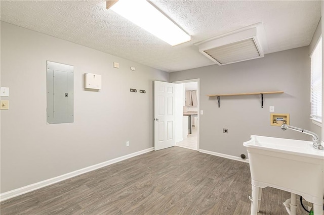 clothes washing area featuring electric dryer hookup, washer hookup, electric panel, a textured ceiling, and dark hardwood / wood-style flooring