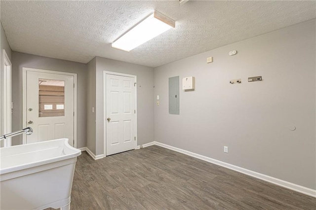 interior space featuring a textured ceiling, electric panel, and dark hardwood / wood-style flooring