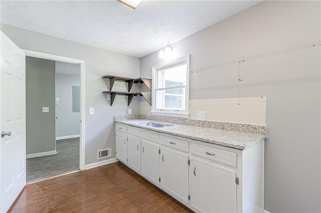 kitchen with sink, white cabinetry, a textured ceiling, and dark hardwood / wood-style flooring