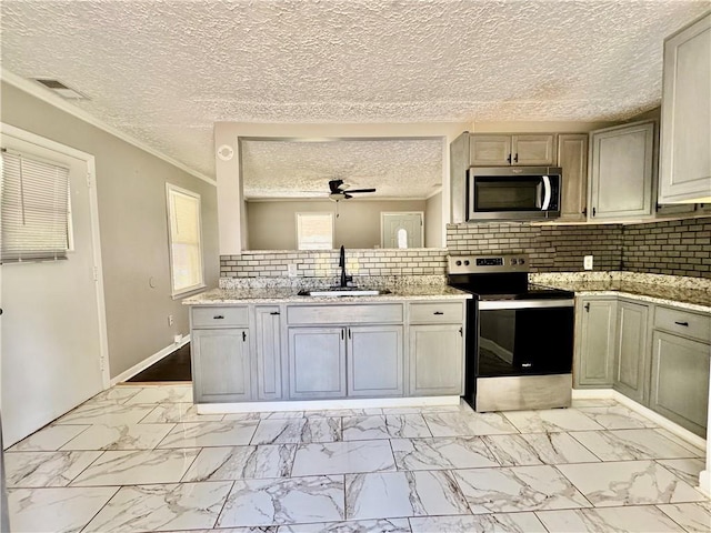 312 E Broad St, Winder, GA 30680 - kitchen with appliances with stainless steel finishes, a sink, light marble finish floors, backsplash, and a ceiling fan