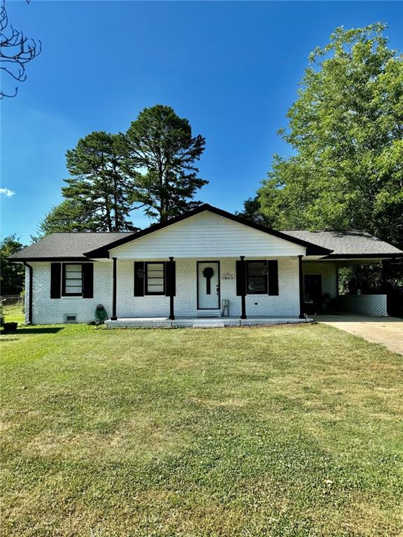 312 E Broad St, Winder, GA 30680 - single story home with brick siding, driveway, a porch, a front lawn, and an attached carport