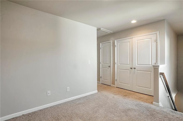 unfurnished bedroom featuring light colored carpet and a closet