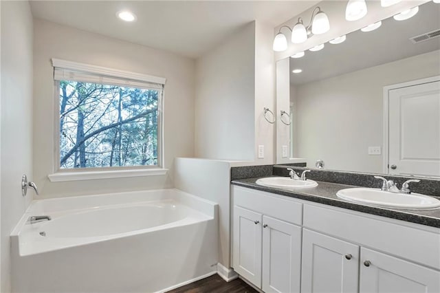 bathroom featuring vanity, hardwood / wood-style floors, and a bathtub