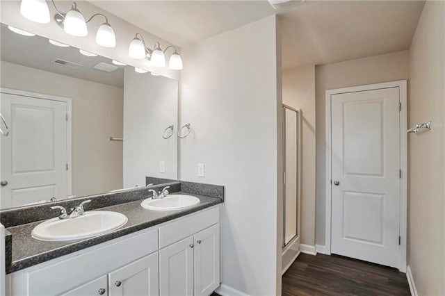 bathroom featuring vanity, wood-type flooring, and a shower with door