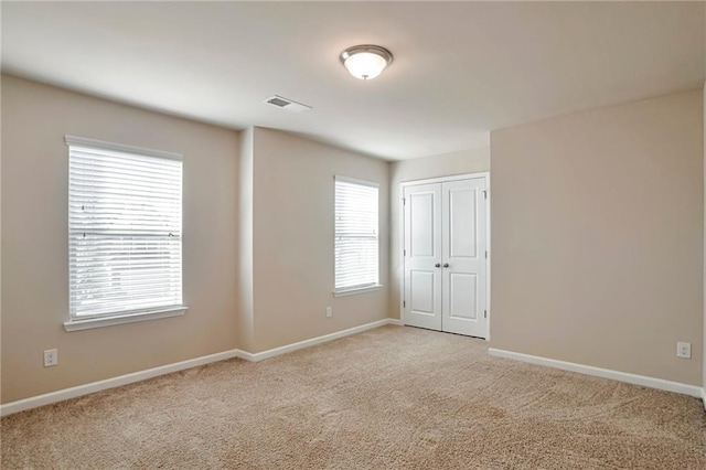 unfurnished room featuring light carpet