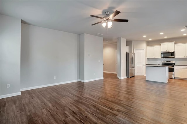 unfurnished living room featuring ceiling fan and hardwood / wood-style floors