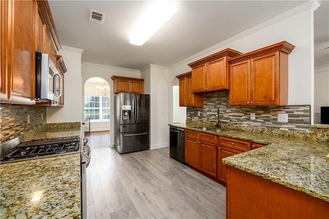 1076 Scenic Park Trl, Lawrenceville, GA 30046 - kitchen with appliances with stainless steel finishes, a sink, arched walkways, light stone counters, and ornamental molding